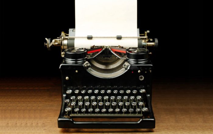 Black typewriter with a blank paper inside