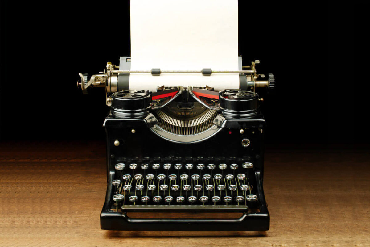 Black typewriter with a blank paper inside