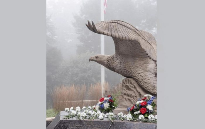 Eagle statue, American flag pole in background