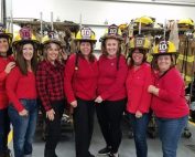 Lincroft Ladies posing with firefighter headgear