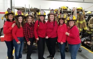 Lincroft Ladies posing with firefighter headgear