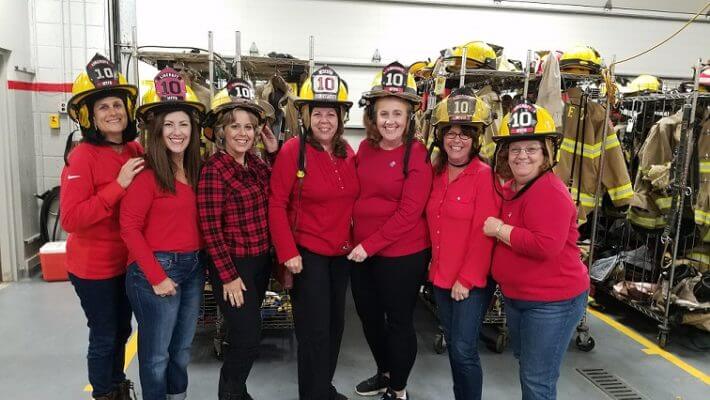 Lincroft Ladies posing with firefighter headgear