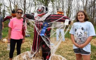 Kids posing by their scarecrow at Thompson Park