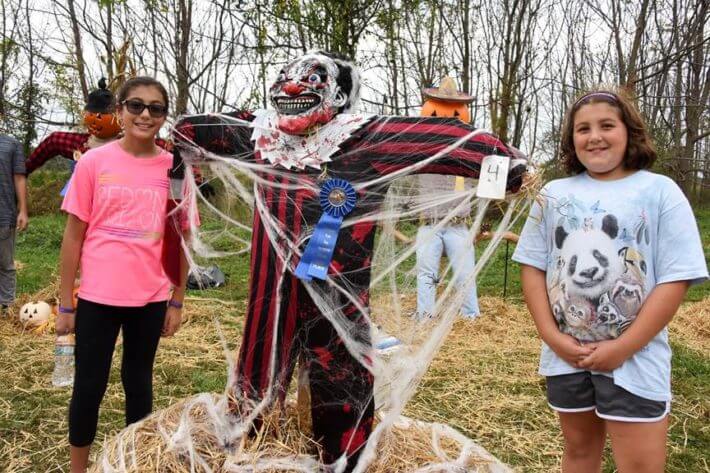 Kids posing by their scarecrow at Thompson Park