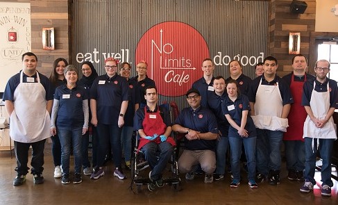 Entire staff in front of cafe sign/wall