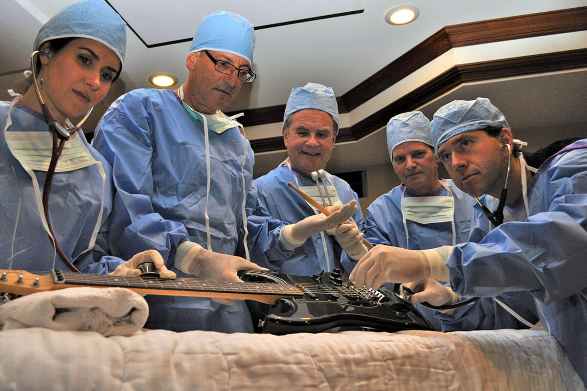 Doctors operating on guitar in emergency room