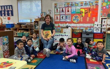 Abby Daly reading a book to children