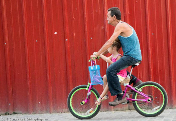 Man riding a bike with a little girl