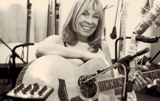 Photo of Rickie Lee Jones, with her guitar