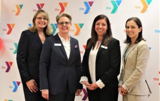 Group of women in front of YMCA bacdrop banner, Merge Event