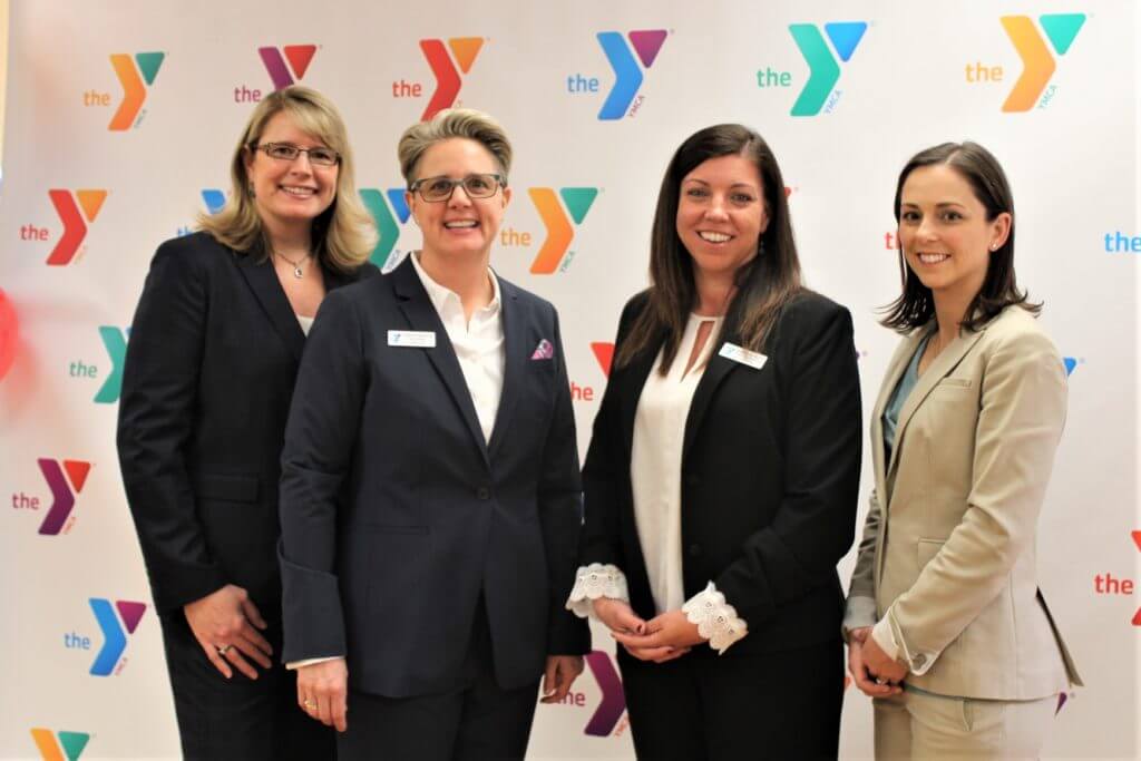 Group of women in front of YMCA bacdrop banner, Merge Event