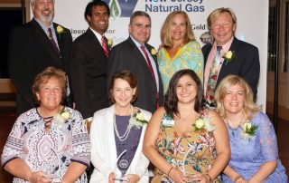 Monmouth Chamber of Commerce members posing in fron tof New Jersey Natrual Gas banner