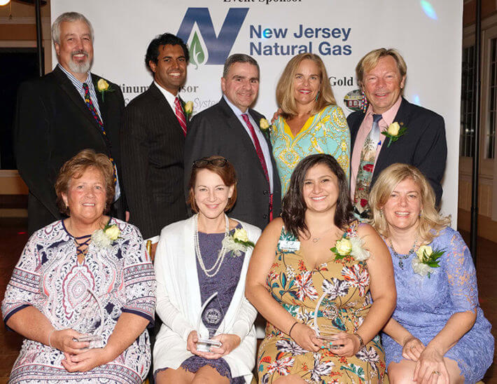 Monmouth Chamber of Commerce members posing in fron tof New Jersey Natrual Gas banner